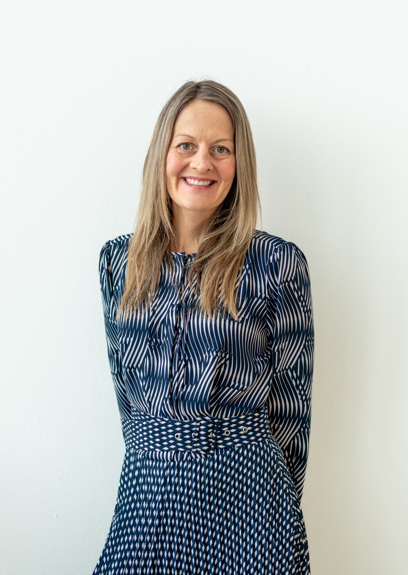 Clare Inkster smiling in a navy patterned dress
